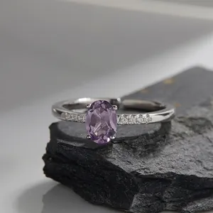 Macro shot of oval purple amethyst ring with pavé-set zircons on silver band