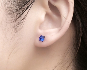 Close-up of minimalist square blue zircon stud earring worn on earlobe for unisex style