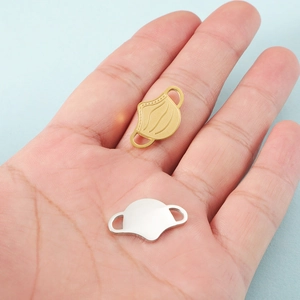 Pendentifs masque en acier doré et argenté sur la paume avec un fond bleu clair épuré