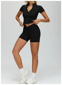 Detail of black seamless yoga set with zip-up short sleeve top and V-waist fitness shorts