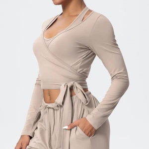 Detail of khaki yoga set showing cross-over tie-waist top and drawstring pocket pants