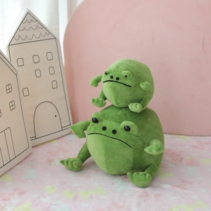 Adorable green frog plush toys in two sizes stacked against a soft pink background