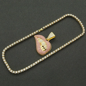 Men's hip hop gold tennis chain with iced out pink lip pendant on black background
