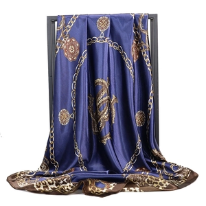 Navy blue satin scarf with golden chain and leopard print draped on a metal frame