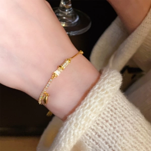 Detail view of gold-plated bamboo bracelet with mother-of-pearl and cubic zirconia