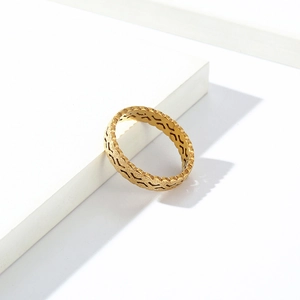Close-up of golden sandblasted titanium ring with wavy hollow design on white base