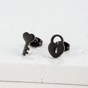 Close-up of black matte stainless steel asymmetric heart key and lock stud earrings