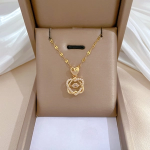 Detail of gold double heart pendant with sparkling cubic zirconia on beige jewelry box