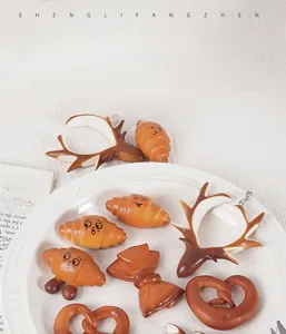 Gedetailleerd beeld van realistische PVC pretzel en croissant hangers met gezichtjes