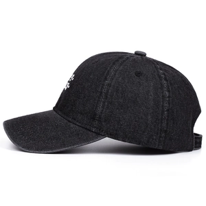Side view of a black denim baseball cap featuring white Lucky letter embroidery