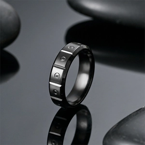 Detailed close-up of a black titanium steel ring with unique geometric recessed segments