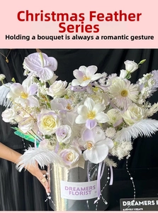 Floral arrangement with white feathers, roses, and pearls in a silver metallic bucket