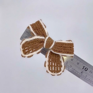 Handmade knitted bow accessory in brown and white wool for DIY garment decoration
