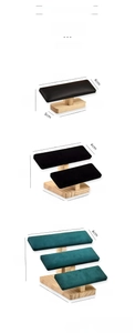 Detail of multi-tier wooden jewelry stand with green velvet and black leather rolls