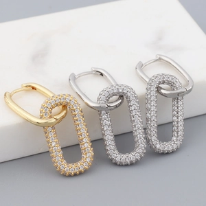 Detailed macro view of geometric paperclip drop earrings in gold, silver, and gunmetal grey