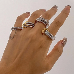 Stacked stainless steel rings with pearls and sparkling charms for a trendy luxury look