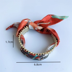 Detail showing 6.8cm diameter and 1.7cm width of a vintage silk scarf gold bangle
