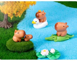 Micro landscape featuring cute capybara figures on grass with blue sand details