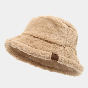 Detail of soft faux fur bucket hat featuring a brown leather patch with snowflake logo