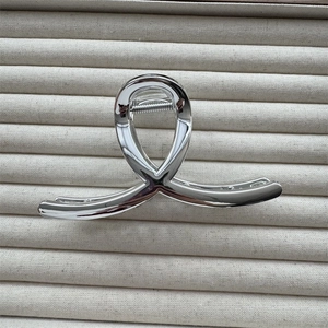 Detail view of a silver metallic twisted hair claw clip with a high-gloss polished finish