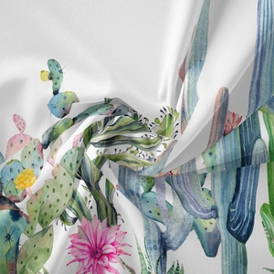 Detail of bohemian tapestry featuring watercolor cactus and flower print on soft fabric