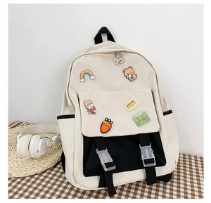 Detail of student backpack with cute cartoon badges and buckles on checkered cloth