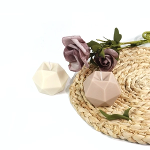 Detail of 3D geometric diamond ball candles in cream white and dusty pink with cotton wicks