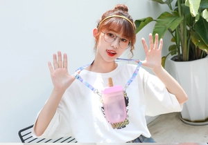 Pink popsicle shaped water bottle with colorful patterned strap worn by a model
