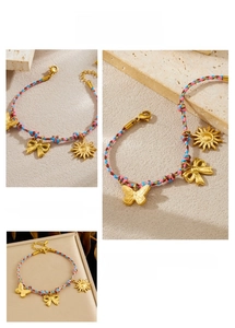 Détail d'un bracelet en corde colorée tissée avec breloques soleil dorées et fermoir homard