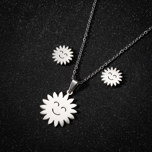 Polished stainless steel smiling sun necklace and earrings jewelry set on black background
