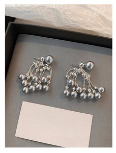 Detail of silver tassel earrings with grey pearls and elegant multi-layer metal chains