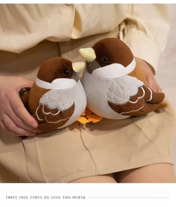 Close-up of soft sparrow plush toy set in different sizes held by a model