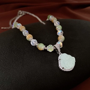 Macro shot of Buddha jade pendant with zircon inlays and colorful crystal beaded chain