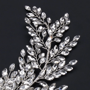 Close-up of handmade bridal headband with clear crystals and silver wire leaf design