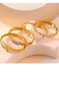Detailed view of four gold-plated chain bracelets with rhinestone accents on a prop