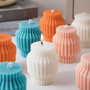 Detailed view of pleated cylinder scented candles in various colors for home decor