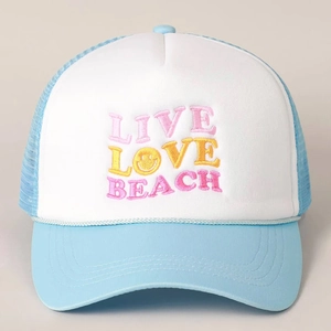 Close-up of LIVE LOVE BEACH embroidery and mesh detail on the blue trucker hat