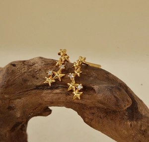 Detailed view of S925 silver star earrings with gold finish and sparkling zircon stones