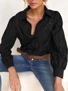 Detail view of black hollow-out embroidery and puff sleeves on a casual woman shirt