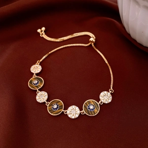 Detailed shot of 18k gold plated bracelet with tiger eye stone on red silk background