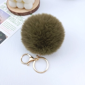 Close-up of army green plush pompom keychain with premium golden metal clasp fastener