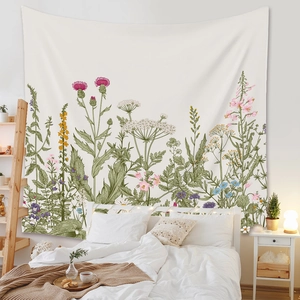 Close-up of bohemian floral tapestry featuring vintage botanical illustrations on white wall