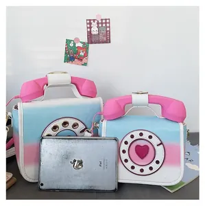 Detail view of retro telephone-shaped crossbody bags in pink-blue gradient leather