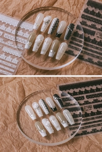 Detail of 5D embossed lace nail art with pearls and rhinestones on long coffin shaped nails