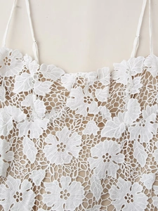 Détail de la broderie en dentelle florale blanche sur robe à fines bretelles