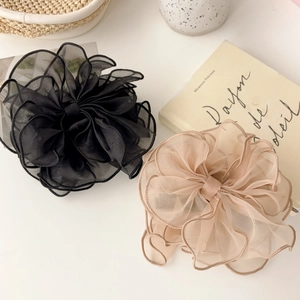 Détail de chouchous en tulle beige et noir sur une table blanche avec décor français