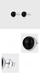 Detail of S925 sterling silver stamp and black agate stud earrings on white backdrop