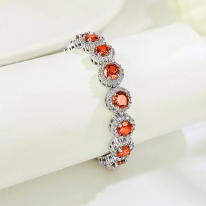 Silver tennis bracelet with round orange stones and white zircon halo in a luxury style