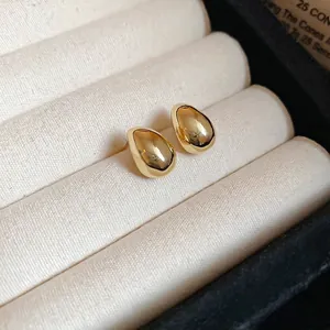 Elegant 18K gold plated teardrop stud earrings displayed on a soft beige velvet box