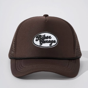Detailed view of dark brown trucker hat with Biker Garage embroidery and mesh back